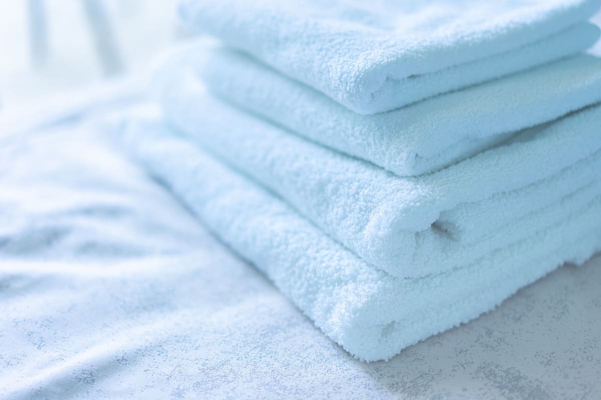 Toalhas brancas dobradas para hotelaria